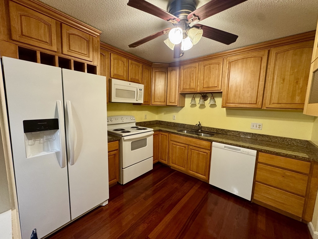 100 Cove Way, Unit 608 Quincy, MA 02169 - Photo 2 of 20 a kitchen with granite countertop wooden floors and white stainless steel appliances