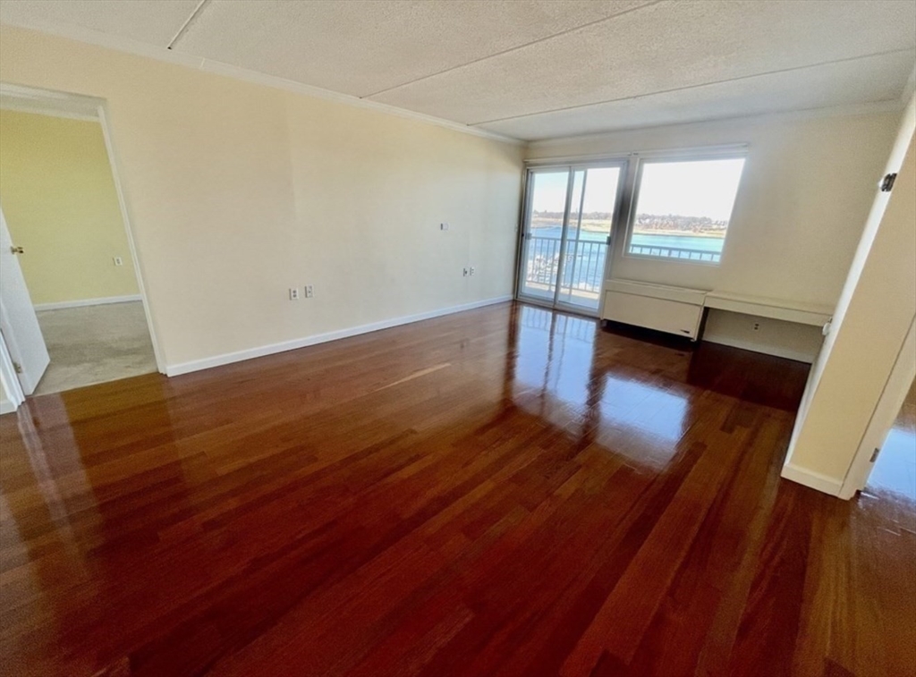 100 Cove Way, Unit 608 Quincy, MA 02169 - Photo 5 of 20 wooden floor in an empty room with a window