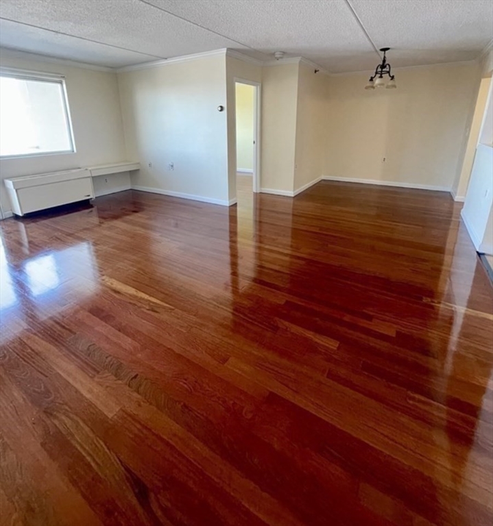 100 Cove Way, Unit 608 Quincy, MA 02169 - Photo 6 of 20 wooden floor in an empty room with a window