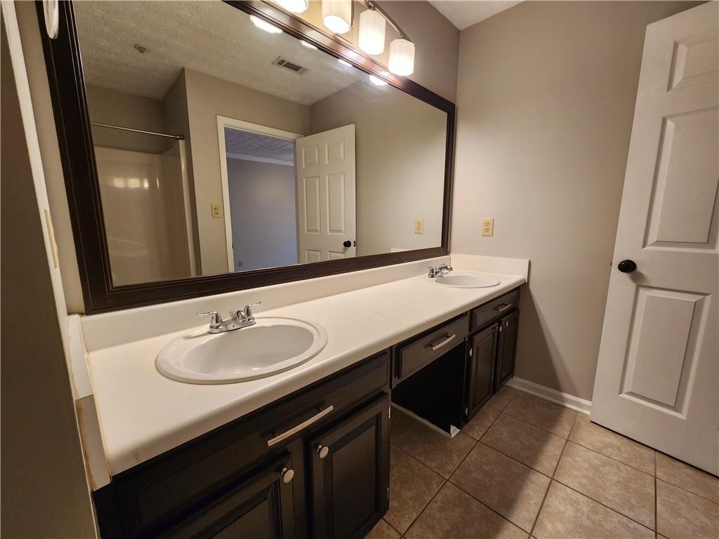 1411 Keys Crossing Drive Northeast Brookhaven, GA 30319 - Photo 18 of 24 a bathroom with a sink a mirror and vanity