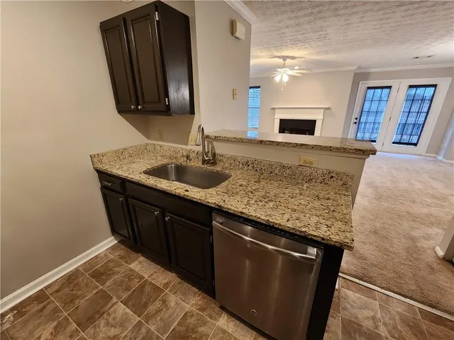 a kitchen with granite countertop a sink and a wooden cabinets