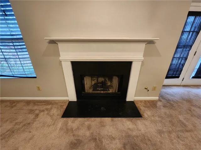 a living room with a fireplace and a rug