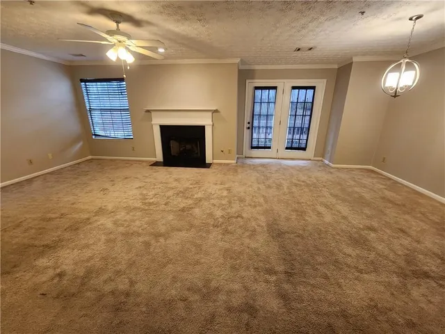 an empty room with windows and fireplace