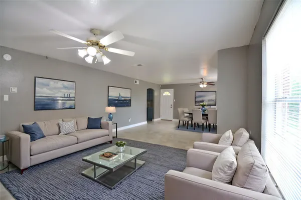 a living room with furniture and a wooden floor