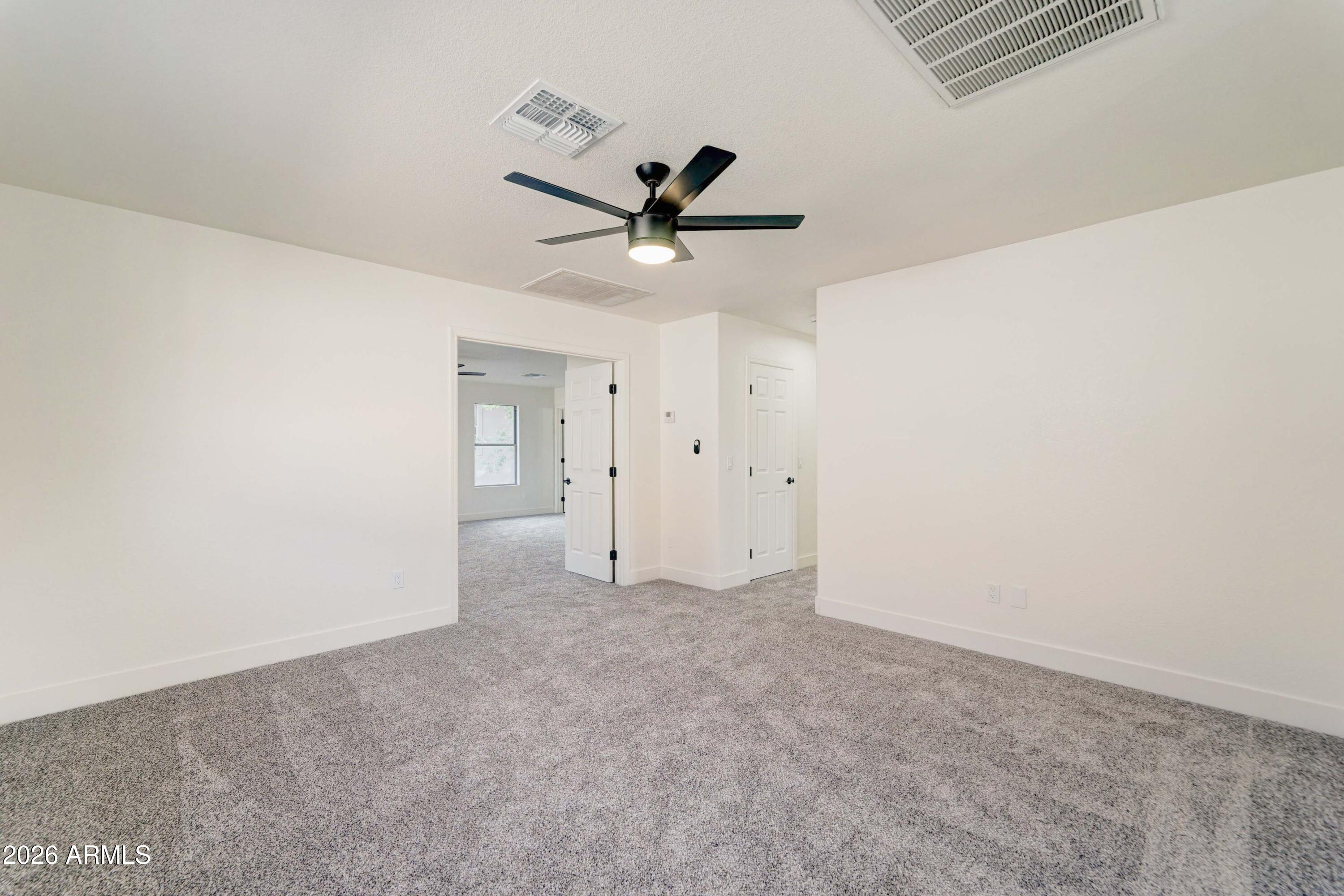 3491 South Chaparral Road Apache Junction, AZ 85119 - Photo 13 of 33 an empty room with a ceiling fan and carpet