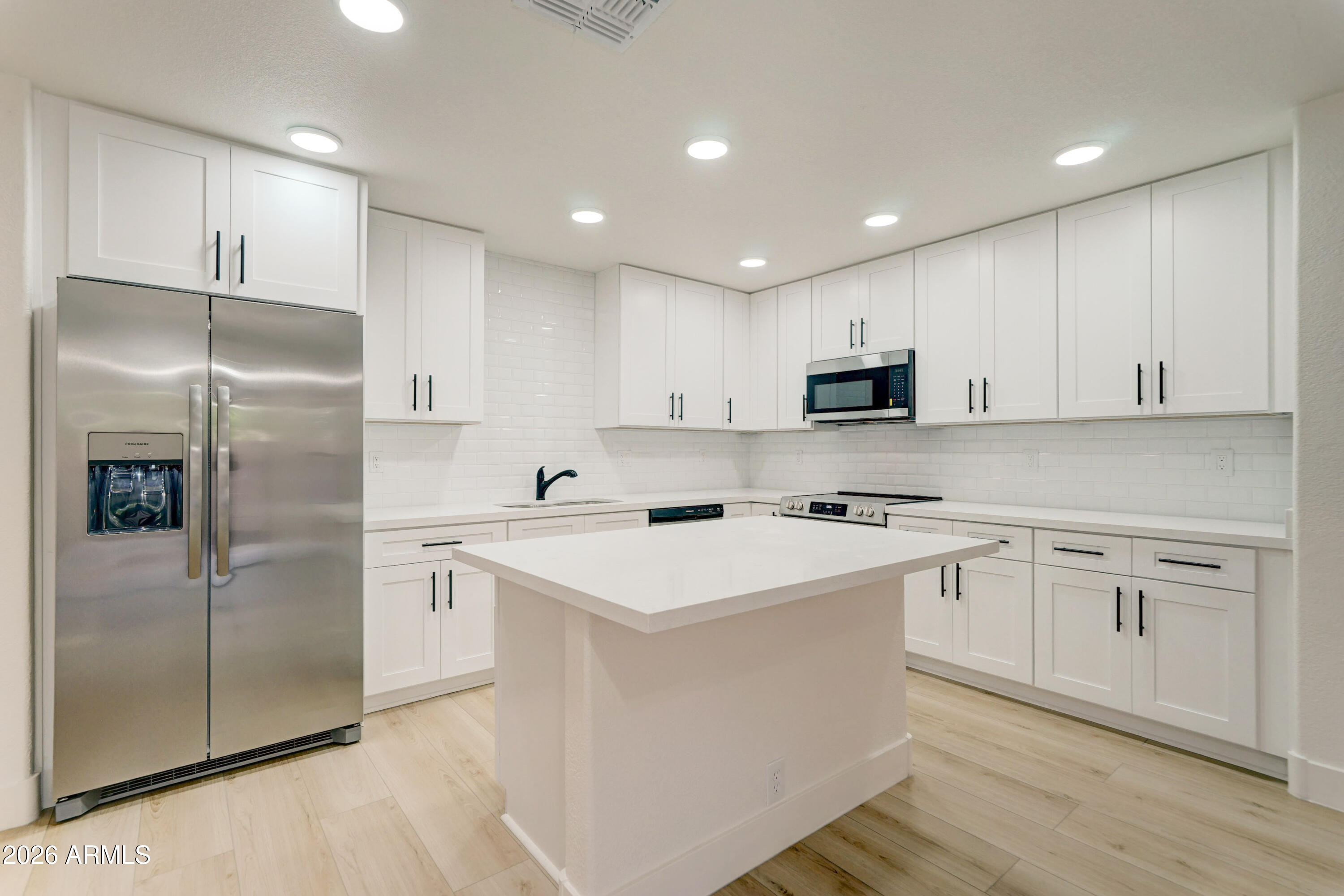 3491 South Chaparral Road Apache Junction, AZ 85119 - Photo 8 of 33 a kitchen with white cabinets and stainless steel appliances