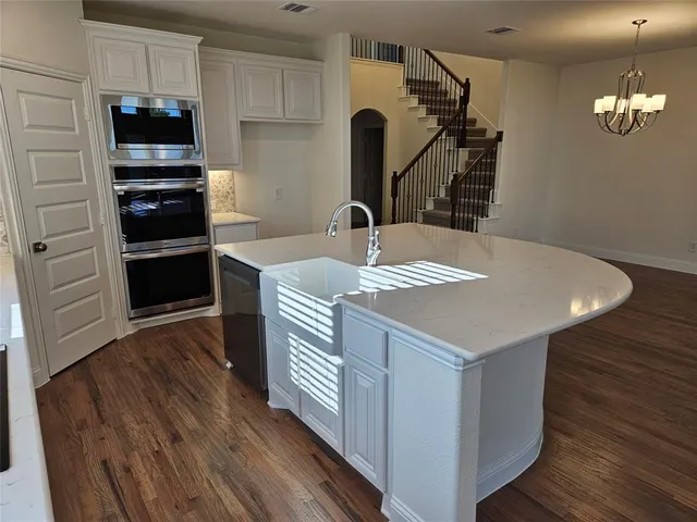 a kitchen with kitchen island a stove and a wooden floor