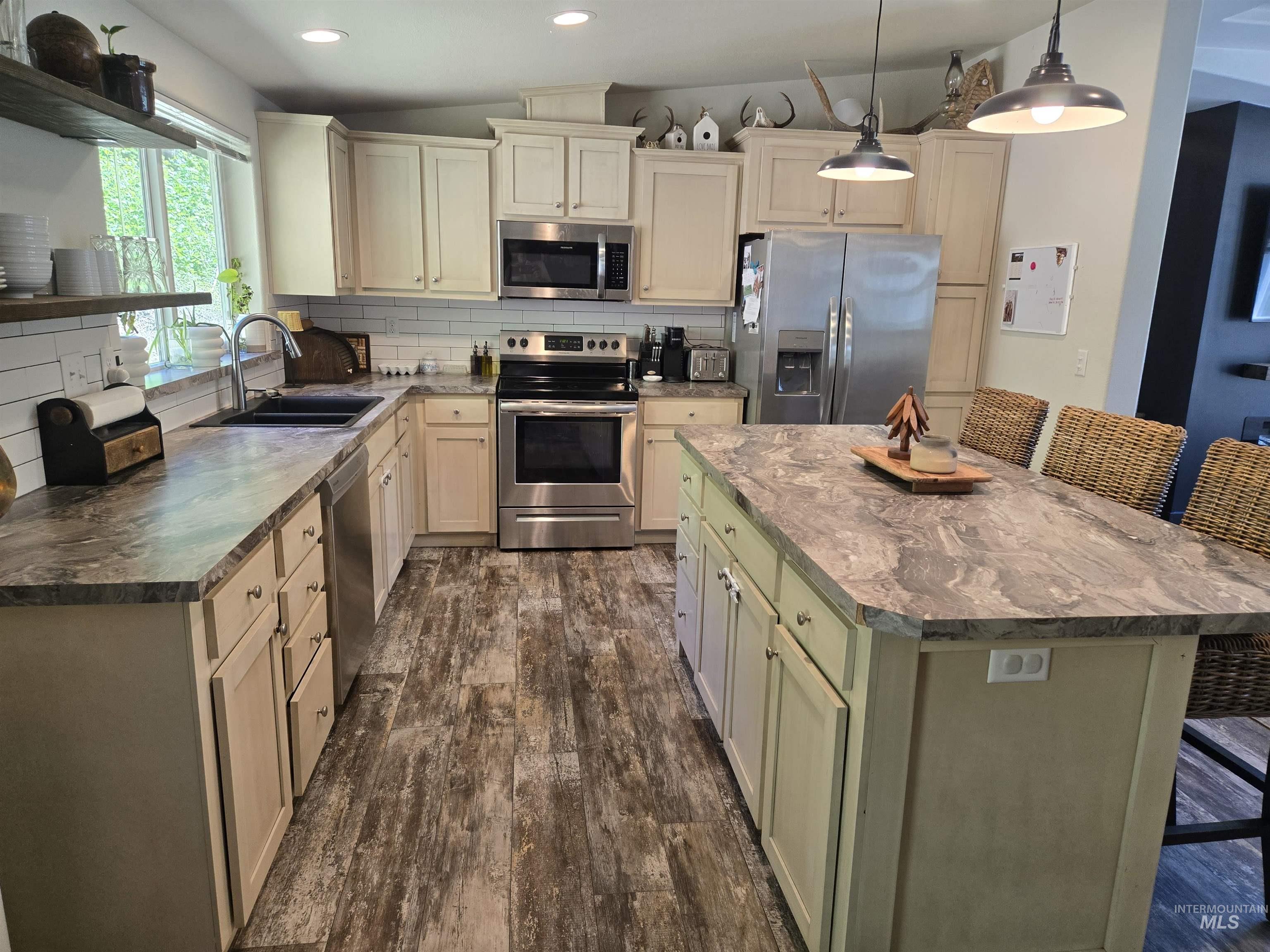 174 Konkolville Road Orofino, ID 83544 - Photo 10 of 43 Contemporary kitchen featuring an island with seating, wood-finish flooring, recessed lighting, and stainless steel appliances