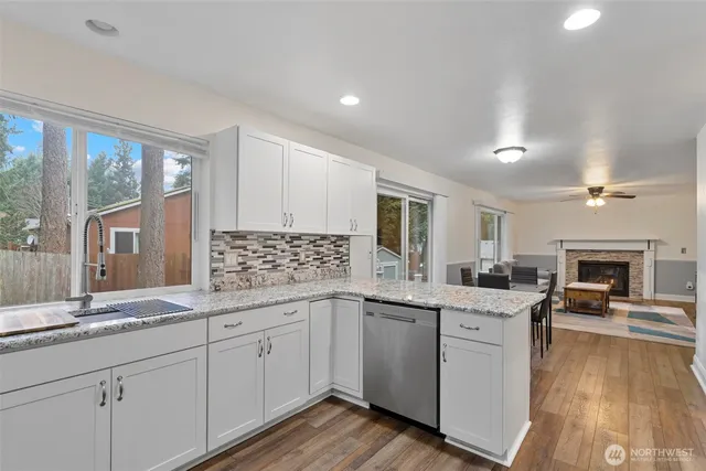 a kitchen with granite countertop a sink stainless steel appliances and cabinets