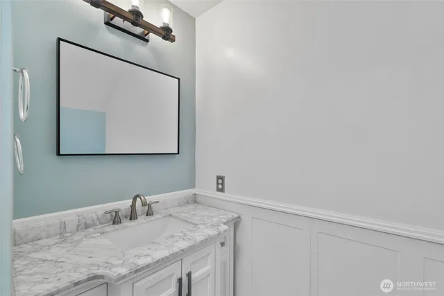a bathroom with a granite countertop sink and a mirror