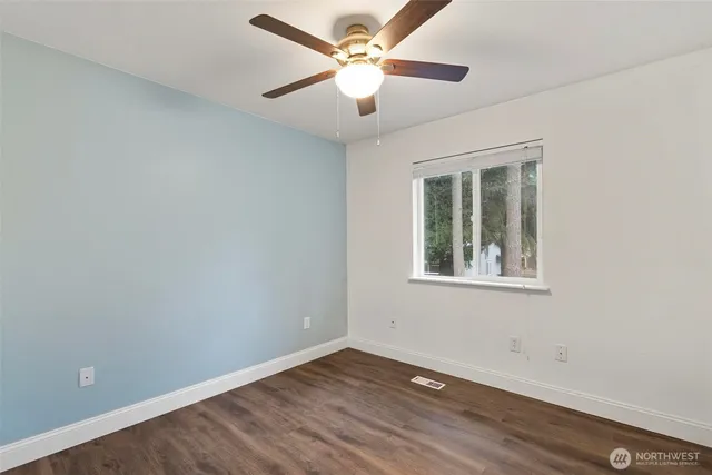 an empty room with a window and a fan