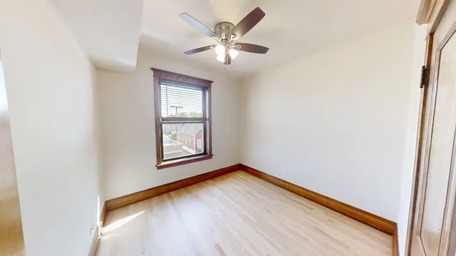 an empty room with windows and fan