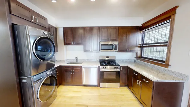 a kitchen with kitchen island granite countertop a stove a sink and a microwave