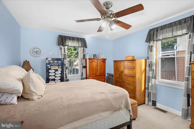 a bedroom with a bed and dresser with window