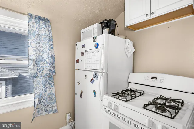 a white refrigerator freezer and a stove sitting inside of a kitchen