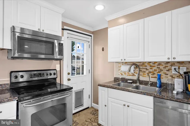 a kitchen with appliances a sink and cabinets