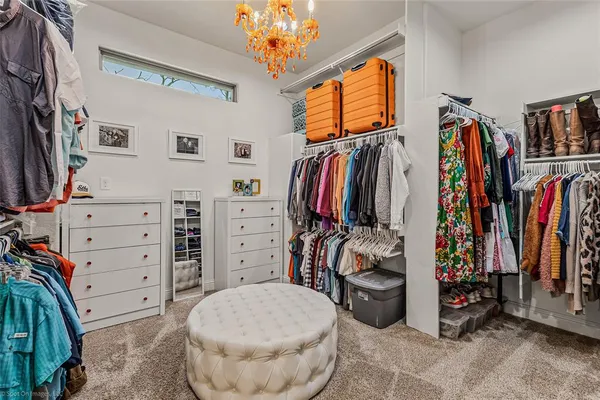 a view of walk in closet with clothes and shoes