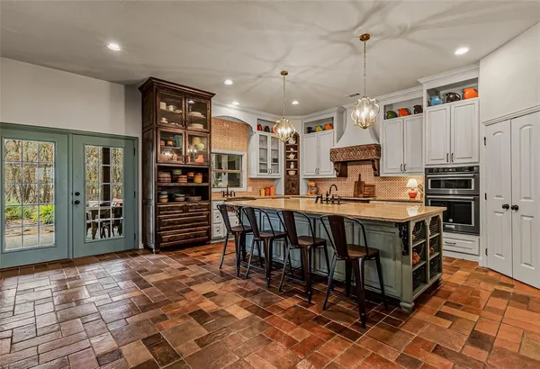 a large kitchen with stainless steel appliances a stove a sink a counter top space and cabinets