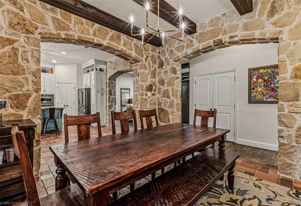 a dining room with wooden floor a chandelier a wooden table and chairs