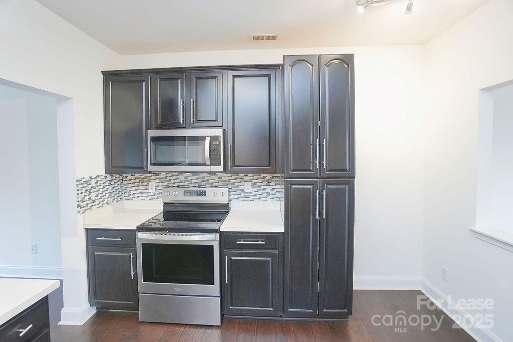 9858 Treeside Lane Matthews, NC 28105 - Photo 11 of 22 a kitchen with granite countertop a stove and a microwave oven
