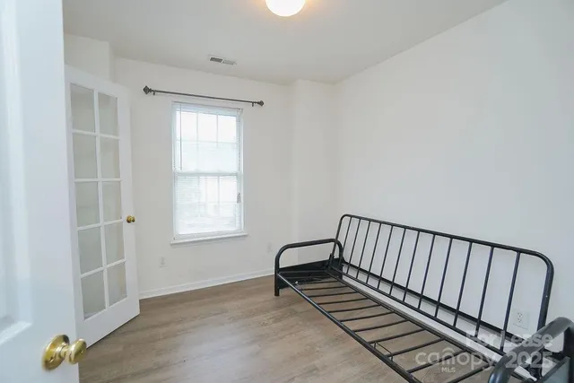 a view of a hallway with wooden floor and a window