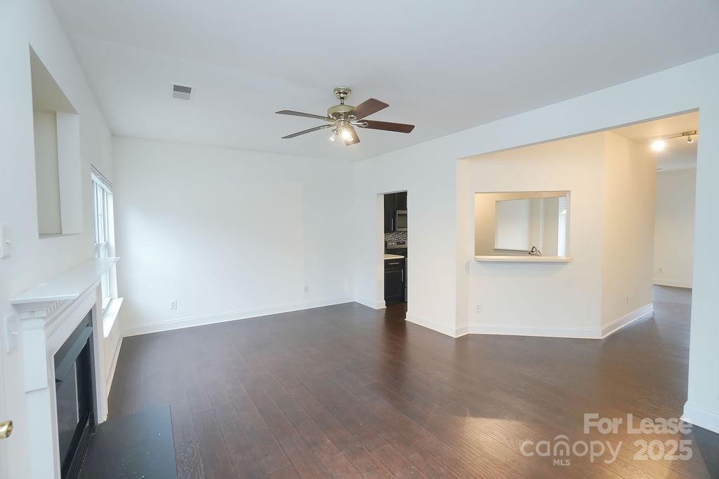 9858 Treeside Lane Matthews, NC 28105 - Photo 7 of 22 a view of an empty room with wooden floor and a ceiling fan