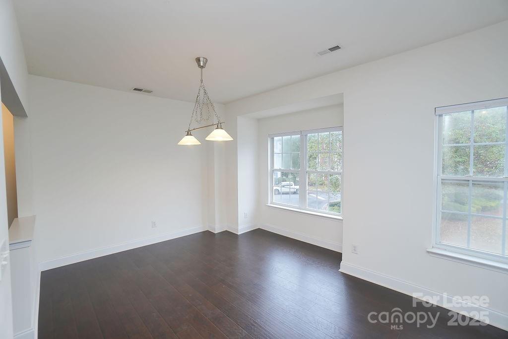 9858 Treeside Lane Matthews, NC 28105 - Photo 8 of 22 a view of an empty room with wooden floor and a window