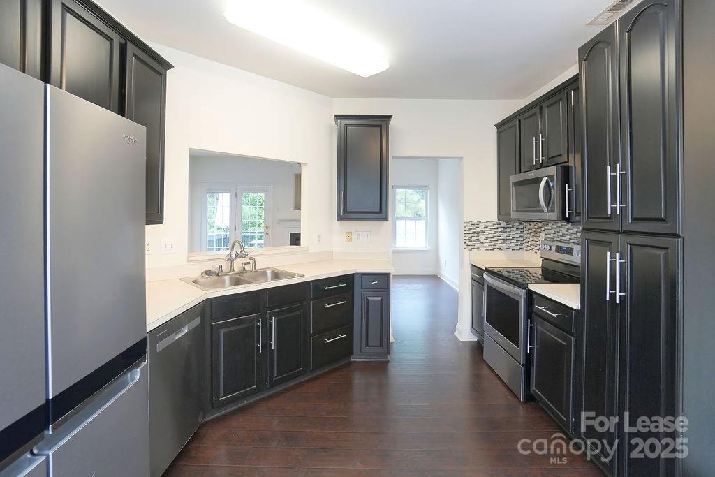 9858 Treeside Lane Matthews, NC 28105 - Photo 9 of 22 a kitchen with stainless steel appliances granite countertop a refrigerator a stove a sink and a microwave