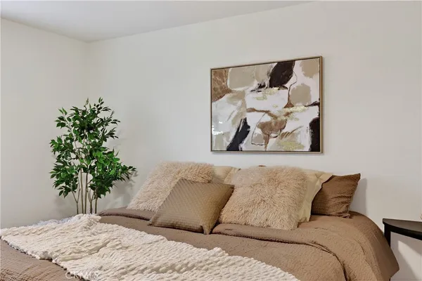 a bedroom with a large bed and a potted plant