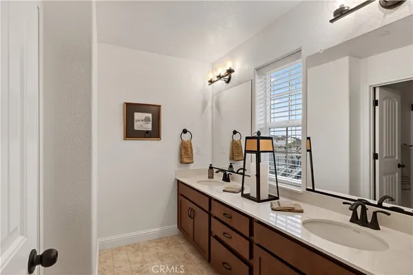 a bathroom with double sink and a mirror