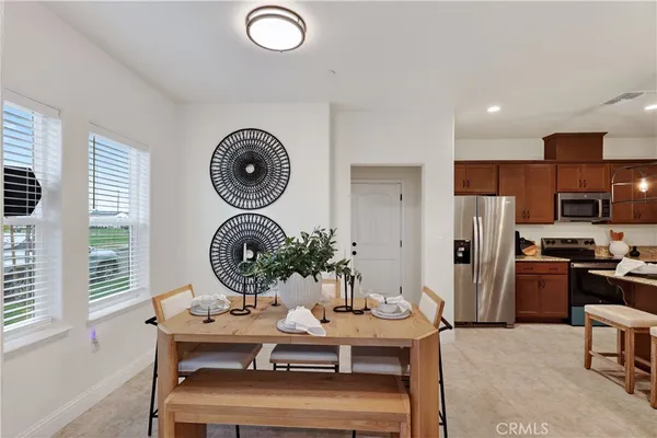 a living room with stainless steel appliances furniture a rug and a window