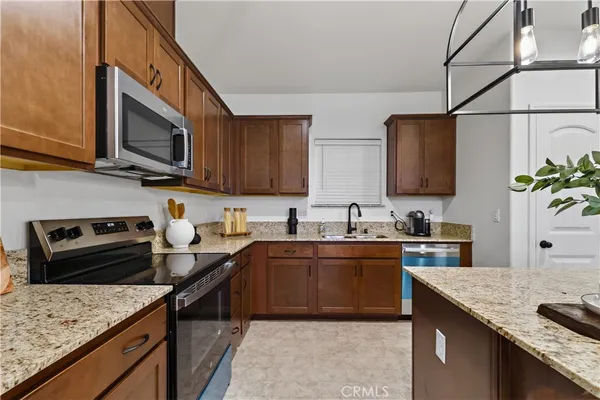 a kitchen with stainless steel appliances granite countertop a sink stove and microwave