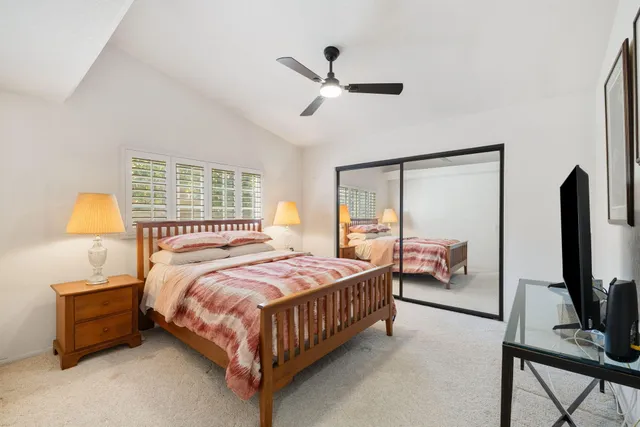 a bedroom with a bed and a flat tv screen on dresser