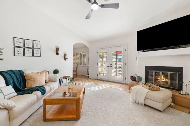 a living room with furniture a fireplace and a flat screen tv