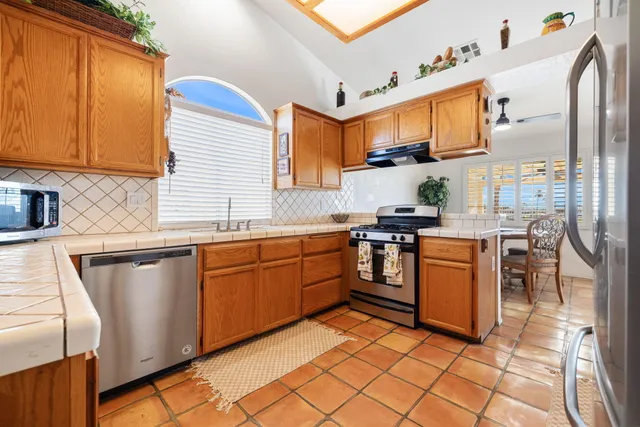 a kitchen with stainless steel appliances granite countertop a sink and cabinets
