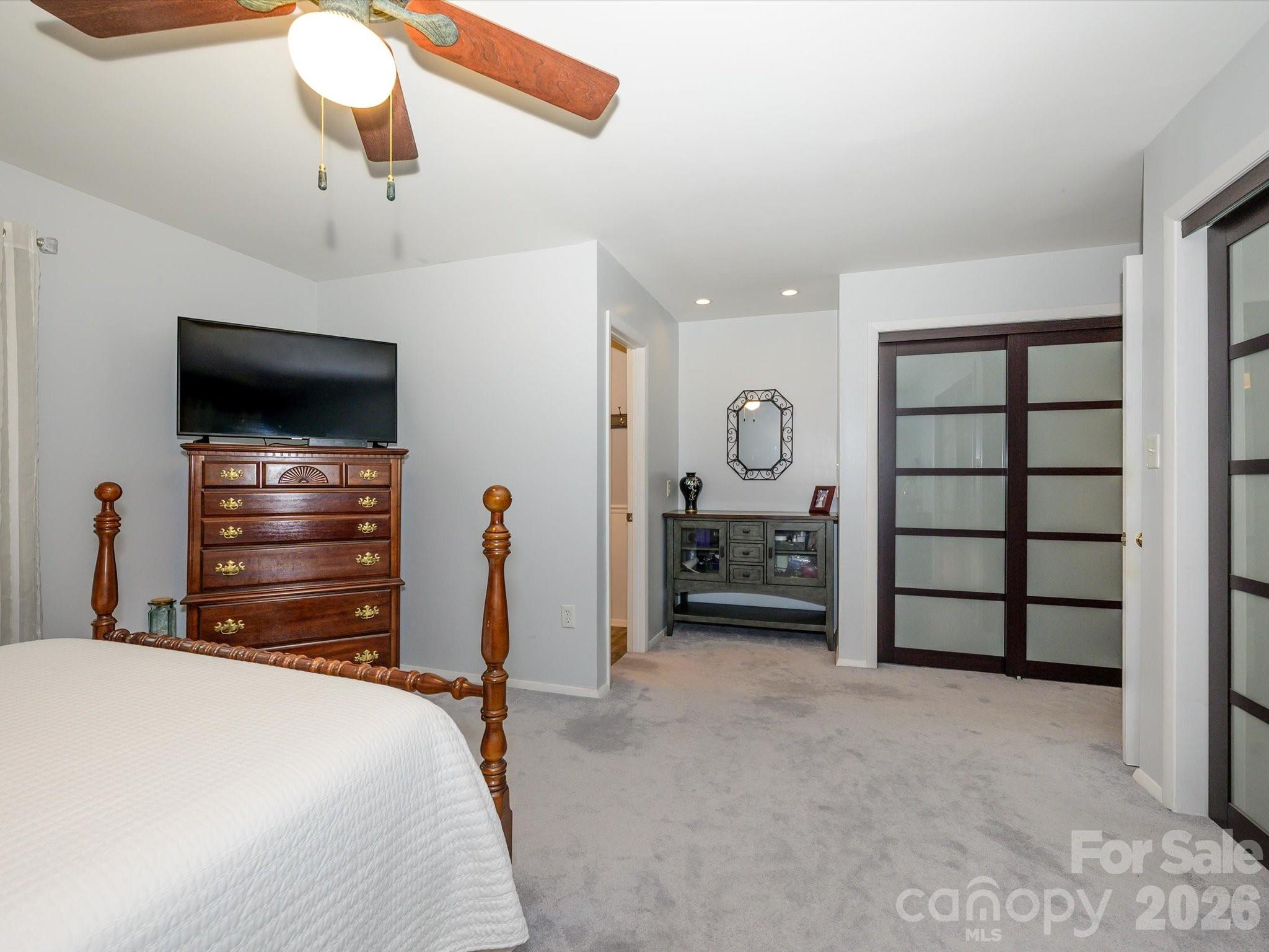 9607 Riddick Place Matthews, NC 28105 - Photo 23 of 39 a bedroom with a bed and a flat tv screen on dresser