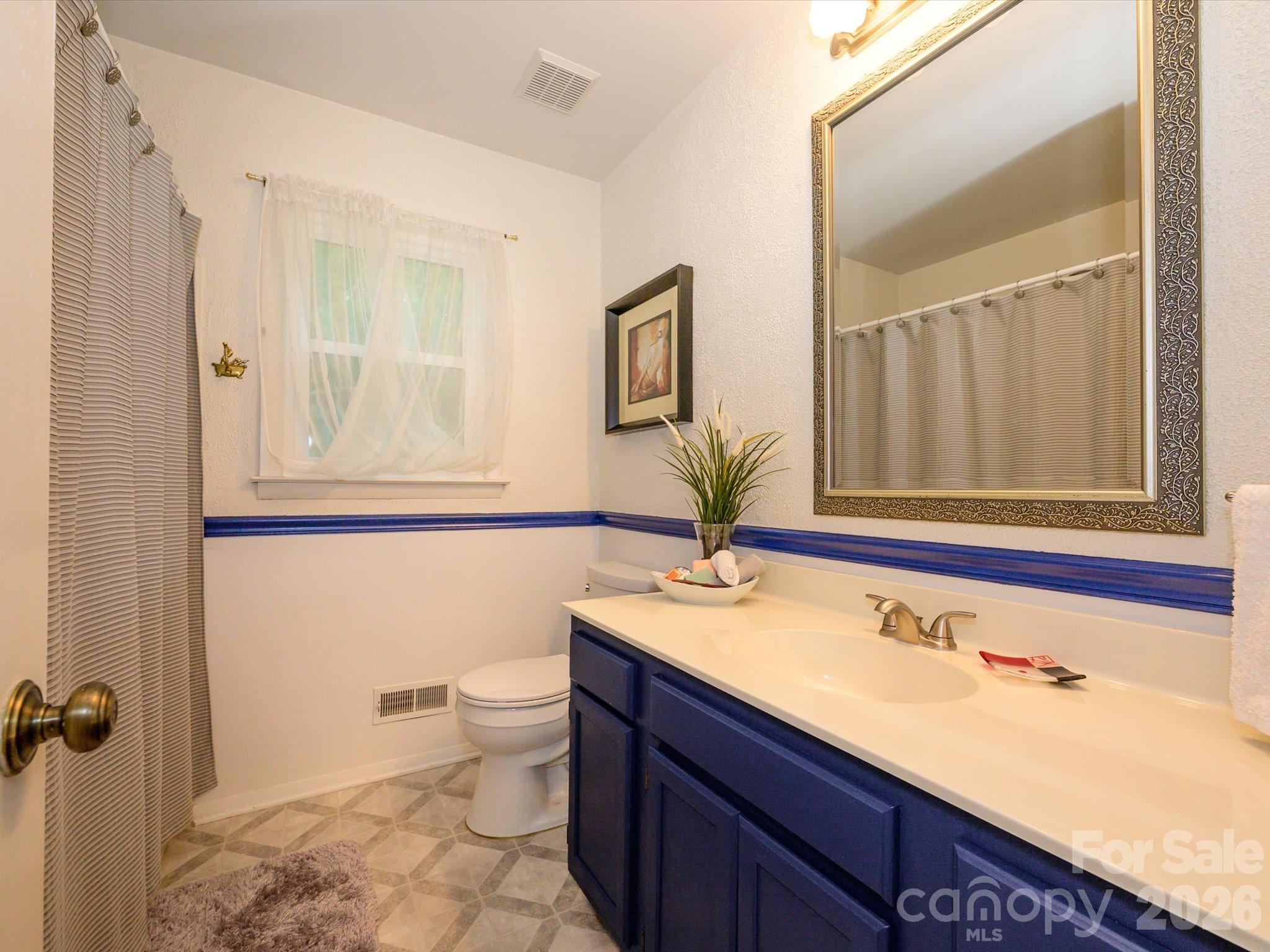 9607 Riddick Place Matthews, NC 28105 - Photo 31 of 39 a bathroom with a granite countertop sink toilet and mirror