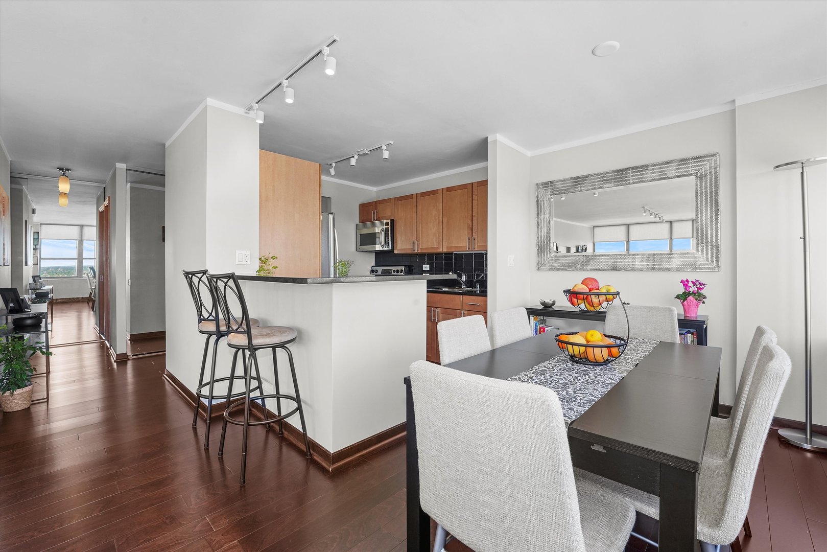 655 West Irving Park Road, Unit 3916 Chicago, IL 60613 - Photo 6 of 17 a kitchen with stainless steel appliances granite countertop a dining table chairs and a refrigerator
