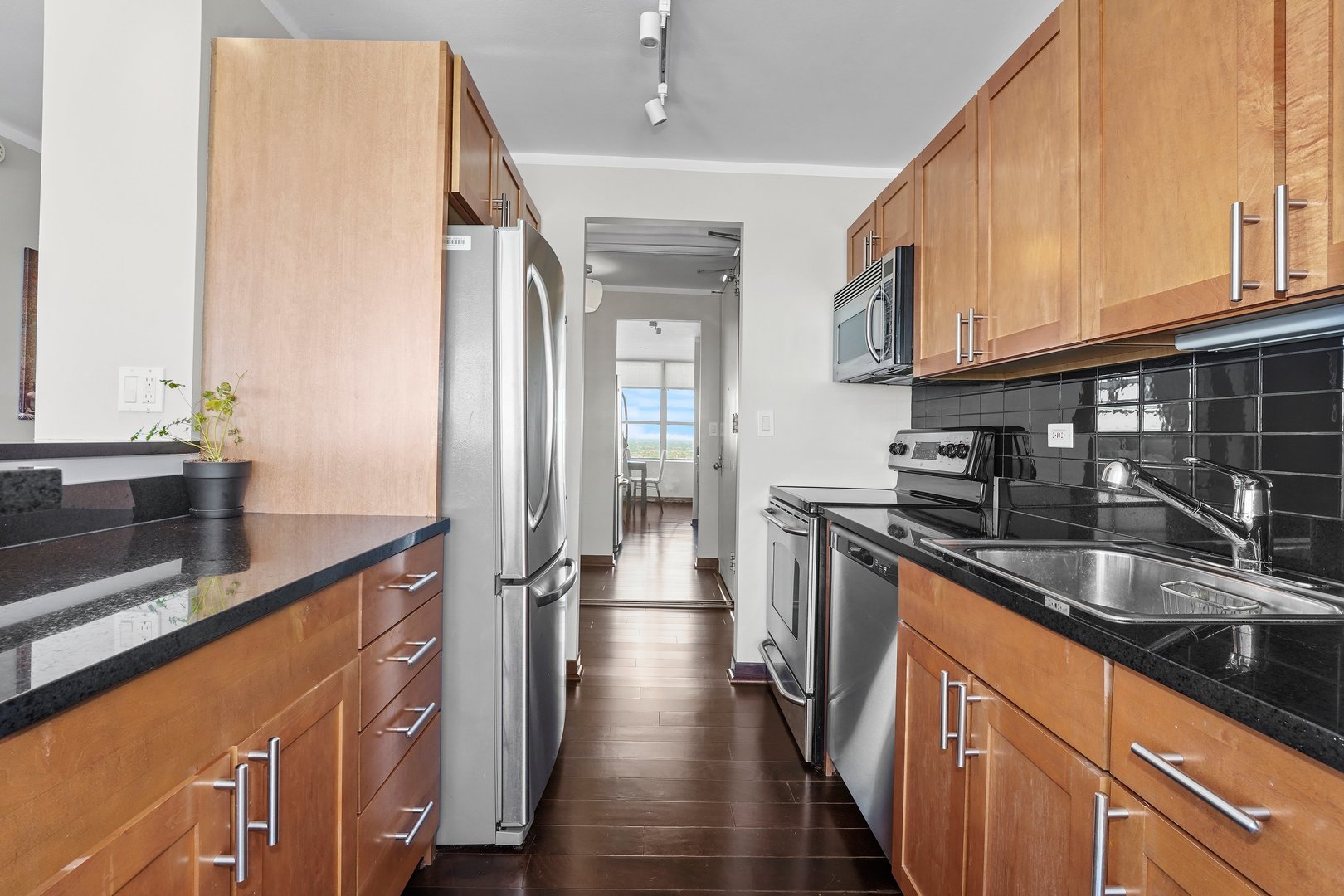 655 West Irving Park Road, Unit 3916 Chicago, IL 60613 - Photo 8 of 17 a kitchen with stainless steel appliances granite countertop a sink a stove and a wooden floors