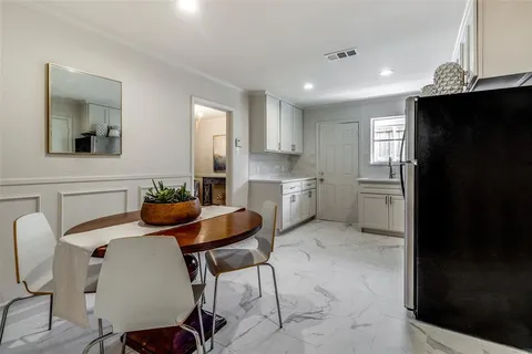 a kitchen with a table chairs and refrigerator