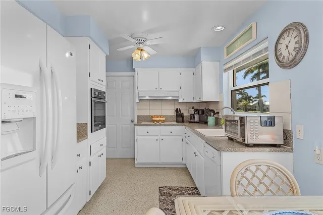 a large white kitchen with stainless steel appliances