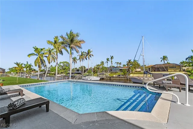 a view of swimming pool with outdoor seating and plants