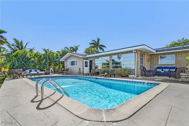 a view of a house with swimming pool and sitting area