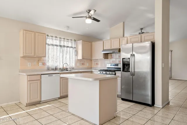 a kitchen with a sink cabinets stainless steel appliances and a window