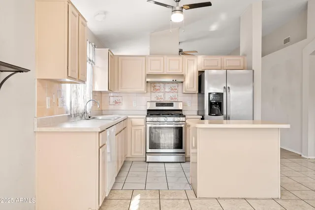 a view of an empty room with window and chandelier fan