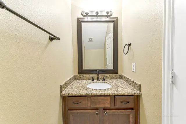 a bathroom with a granite countertop sink and a mirror