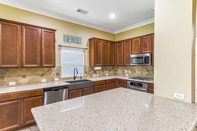 a kitchen with stainless steel appliances granite countertop a sink stove and refrigerator