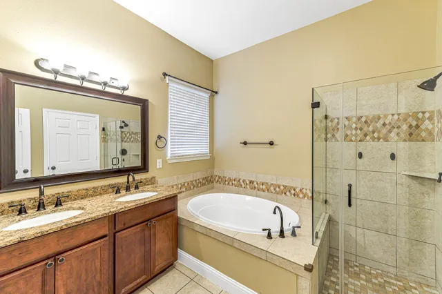 a bathroom with a tub a sink and mirror