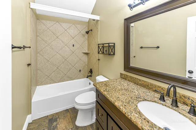 a bathroom with a granite countertop sink toilet and shower