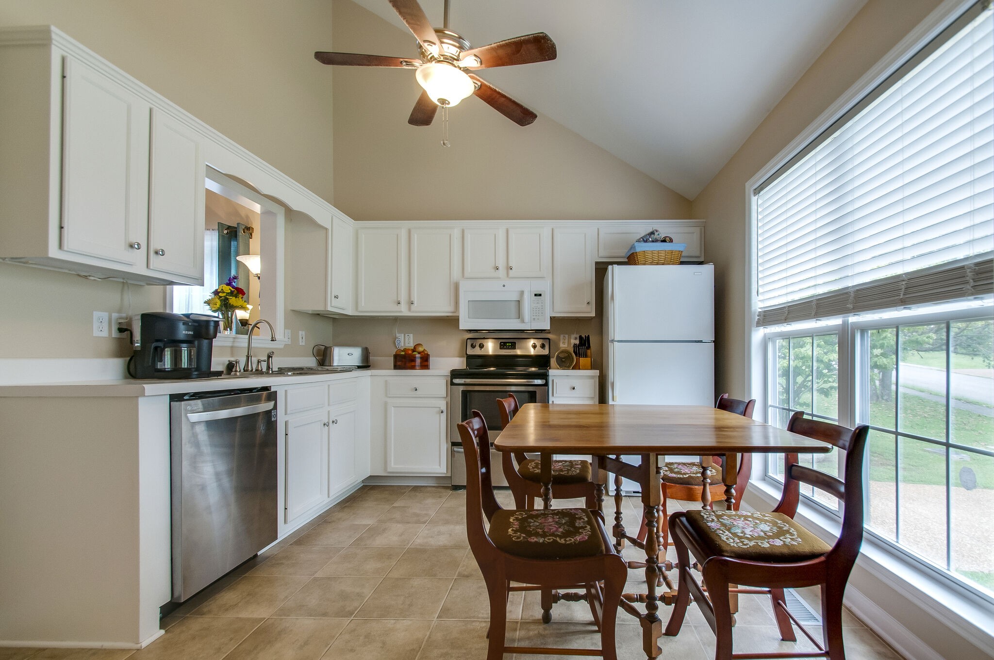 7487 Christopher Street Fairview, TN 37062 - Photo 14 of 27 a kitchen with granite countertop a table chairs microwave and cabinets